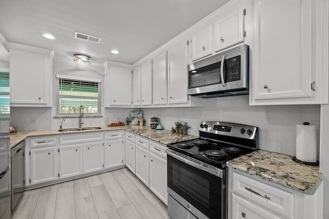 5709 David St, Dickinson, TX 77539 - kitchen featuring stainless steel appliances, white cabinetry, backsplash, recessed lighting, and light stone counters