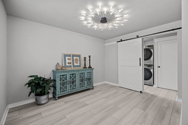 5709 David St, Dickinson, TX 77539 - washroom with a barn door, estacked washer and dryer, and light wood-style flooring