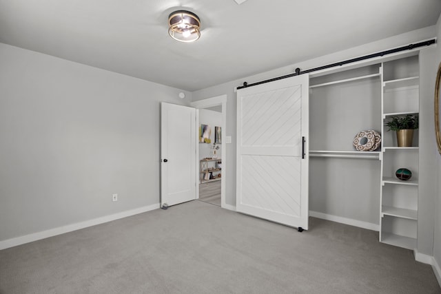 5709 David St, Dickinson, TX 77539 - unfurnished bedroom featuring carpet, a barn door, and a closet