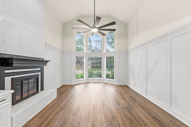 12135 Quail Creek Dr, Houston, TX 77070 - unfurnished living room featuring a decorative wall, high vaulted ceiling, a ceiling fan, a brick fireplace, and wood finished floors