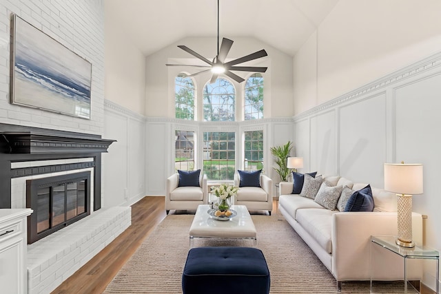 12135 Quail Creek Dr, Houston, TX 77070 - living area with a decorative wall, high vaulted ceiling, a ceiling fan, wood finished floors, and a fireplace