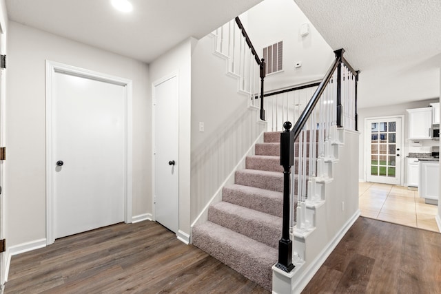 12135 Quail Creek Dr, Houston, TX 77070 - foyer with stairs, wood finished floors, and a textured ceiling