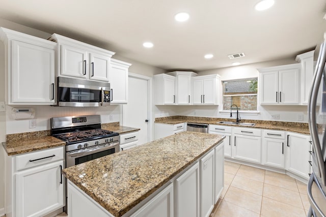 12135 Quail Creek Dr, Houston, TX 77070 - kitchen featuring appliances with stainless steel finishes, a center island, white cabinets, light stone counters, and recessed lighting