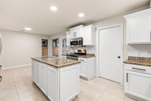 12135 Quail Creek Dr, Houston, TX 77070 - kitchen with stainless steel appliances, a center island, white cabinetry, light tile patterned floors, and recessed lighting