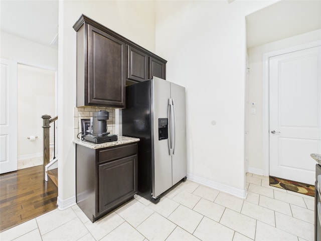 22 Tassia Ln, Pasadena, TX 77058 - kitchen with stainless steel refrigerator with ice dispenser, dark brown cabinets, light stone countertops, and light tile patterned flooring
