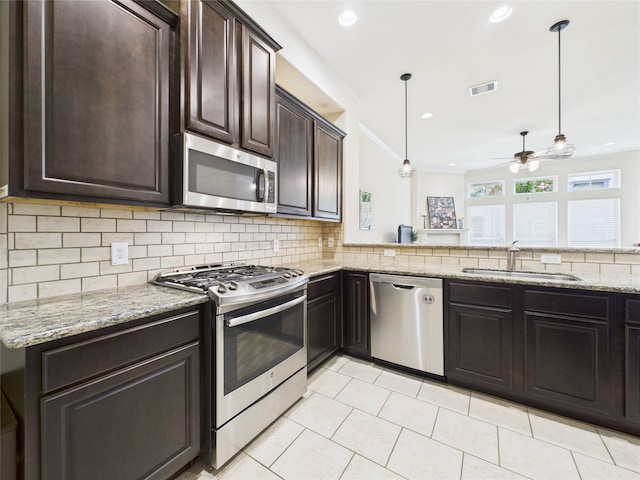 22 Tassia Ln, Pasadena, TX 77058 - kitchen with stainless steel appliances, dark brown cabinetry, a ceiling fan, backsplash, and light tile patterned floors