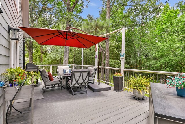 561 N Royale Greens Dr, Coldspring, TX 77331 - wooden deck with outdoor dining space and view of scattered trees