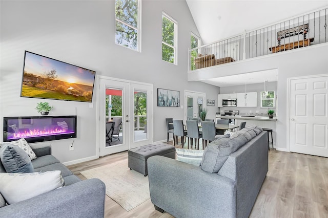 561 N Royale Greens Dr, Coldspring, TX 77331 - living room with high vaulted ceiling, light wood-style flooring, french doors, and plenty of natural light