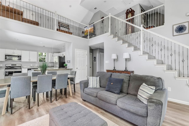 561 N Royale Greens Dr, Coldspring, TX 77331 - living area with high vaulted ceiling, light wood finished floors, and stairway