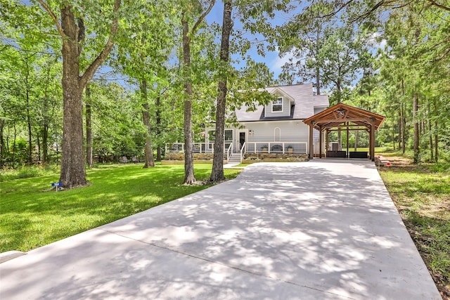 561 N Royale Greens Dr, Coldspring, TX 77331 - view of front facade featuring driveway, a front lawn, and a porch
