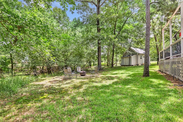 561 N Royale Greens Dr, Coldspring, TX 77331 - view of green lawn featuring a storage unit and an outdoor fire pit