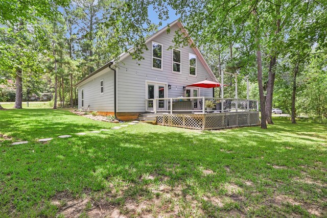 561 N Royale Greens Dr, Coldspring, TX 77331 - rear view of house with a wooden deck and a yard