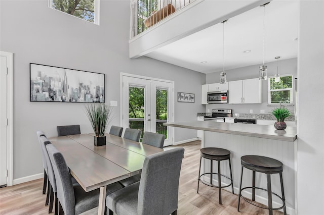 561 N Royale Greens Dr, Coldspring, TX 77331 - dining area with french doors, light wood-type flooring, a towering ceiling, and plenty of natural light