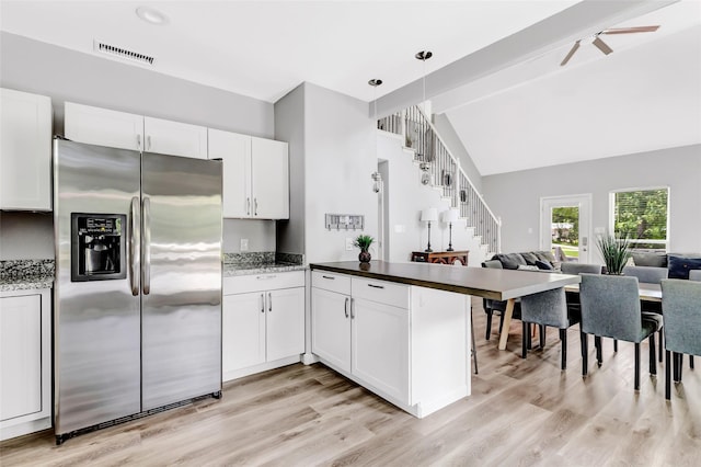 561 N Royale Greens Dr, Coldspring, TX 77331 - kitchen with stainless steel fridge, open floor plan, a peninsula, light wood finished floors, and white cabinetry