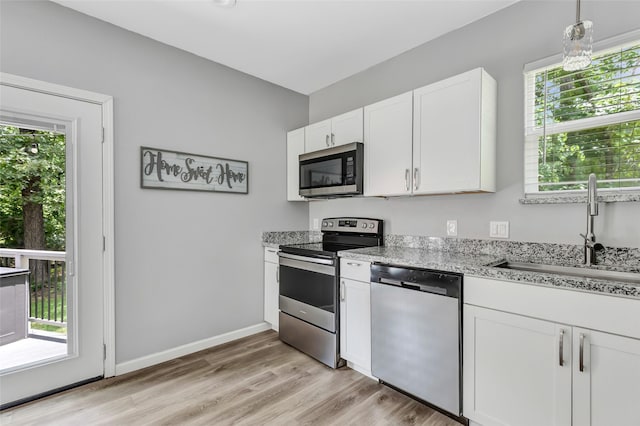 561 N Royale Greens Dr, Coldspring, TX 77331 - kitchen featuring appliances with stainless steel finishes, healthy amount of natural light, and white cabinets
