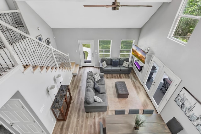 561 N Royale Greens Dr, Coldspring, TX 77331 - living area featuring wood finished floors, ceiling fan, stairs, and plenty of natural light