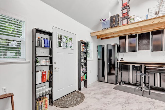 561 N Royale Greens Dr, Coldspring, TX 77331 - kitchen with freestanding refrigerator, vaulted ceiling, light marble finish flooring, and light countertops