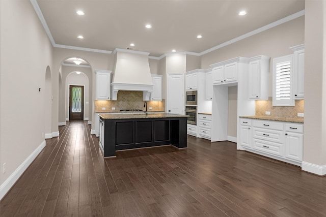 54 N Lochwood Way, Tomball, TX 77375 - kitchen with custom range hood, appliances with stainless steel finishes, backsplash, arched walkways, and recessed lighting