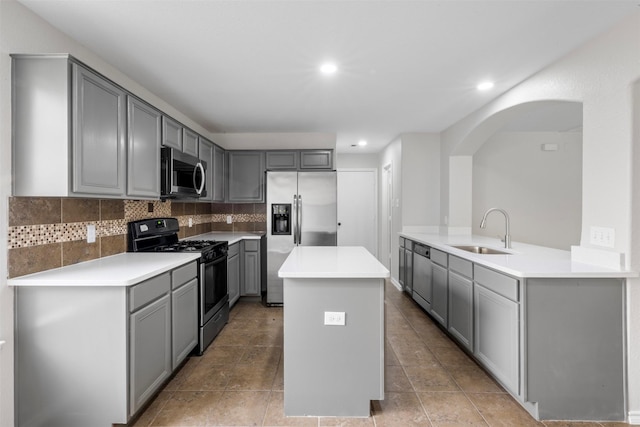 9987 Sterling Place Dr, Conroe, TX 77303 - kitchen with appliances with stainless steel finishes, gray cabinets, a center island, tasteful backsplash, and recessed lighting
