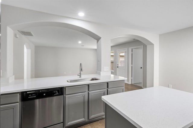 9987 Sterling Place Dr, Conroe, TX 77303 - kitchen featuring dishwasher, gray cabinets, arched walkways, a peninsula, and light countertops