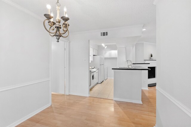 2800 Jeanetta St Unit 2502, Houston, TX 77063 - kitchen featuring freestanding refrigerator, dark countertops, crown molding, white cabinets, and a chandelier