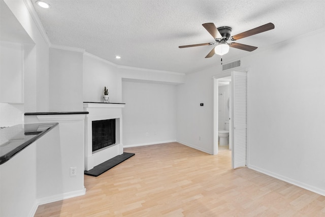 2800 Jeanetta St Unit 2502, Houston, TX 77063 - unfurnished living room with a textured ceiling, a fireplace with raised hearth, a ceiling fan, light wood-type flooring, and ornamental molding