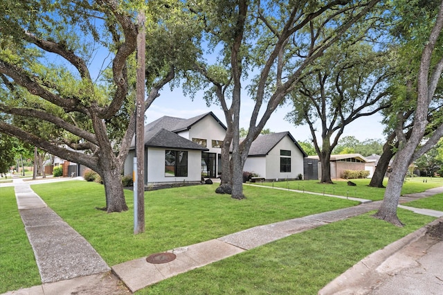 10826 Moonlight Dr, Houston, TX 77096 - view of front of home with stucco siding, a front lawn, and roof with shingles