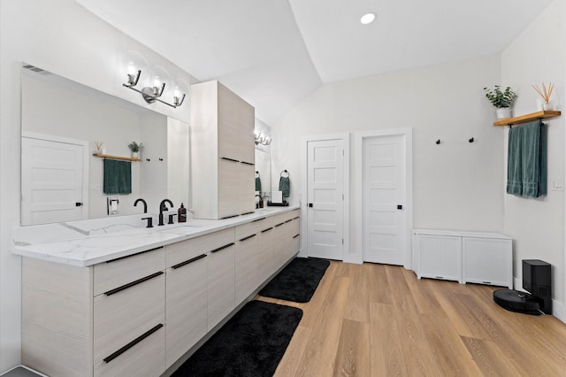 10826 Moonlight Dr, Houston, TX 77096 - bathroom featuring wood finished floors, double vanity, vaulted ceiling, and recessed lighting