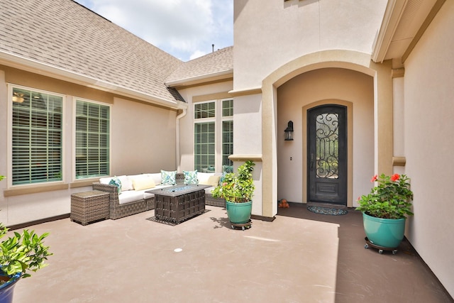 8511 Tynan Ridge Dr, Magnolia, TX 77354 - view of exterior entry with an outdoor hangout area, a shingled roof, stucco siding, and a patio