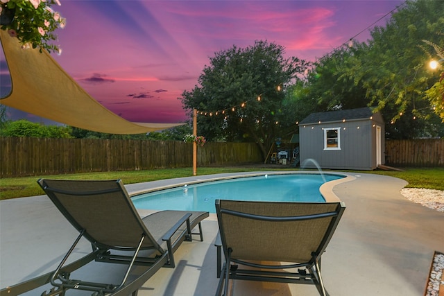 12223 Paddock Way, Houston, TX 77065 - pool at dusk featuring a patio area, a fenced backyard, and a storage shed