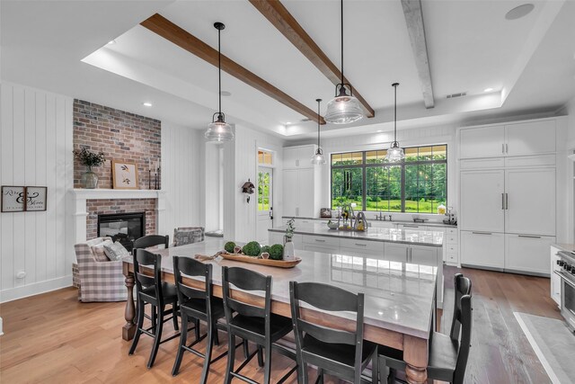 37732 Marias Way, Magnolia, TX 77354 - dining area with light wood finished floors, a brick fireplace, recessed lighting, beamed ceiling, and a raised ceiling