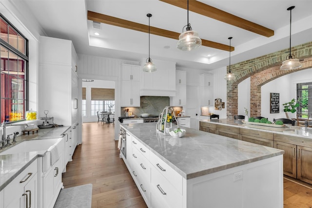 37732 Marias Way, Magnolia, TX 77354 - kitchen with healthy amount of natural light, a spacious island, light wood-type flooring, tasteful backsplash, and beamed ceiling
