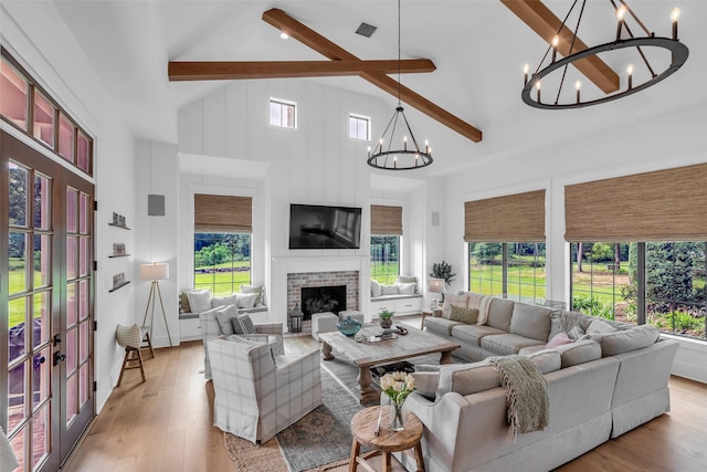 37732 Marias Way, Magnolia, TX 77354 - living room featuring a chandelier, beamed ceiling, light wood-type flooring, french doors, and a fireplace