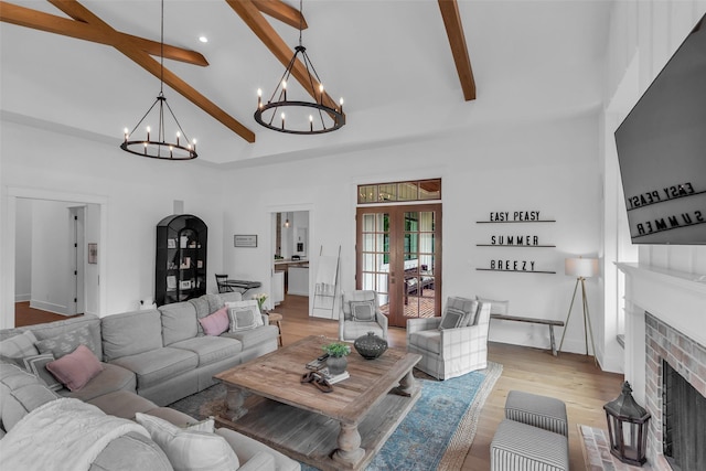 37732 Marias Way, Magnolia, TX 77354 - living room with a chandelier, beamed ceiling, high vaulted ceiling, a fireplace, and light wood-style floors