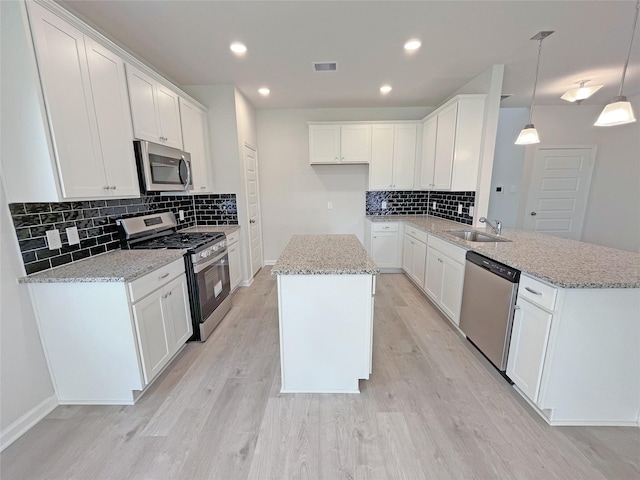 32402 Fly Fish Way, Fulshear, TX 77441 - kitchen with stainless steel appliances, decorative backsplash, a peninsula, a kitchen island, and light wood-style flooring
