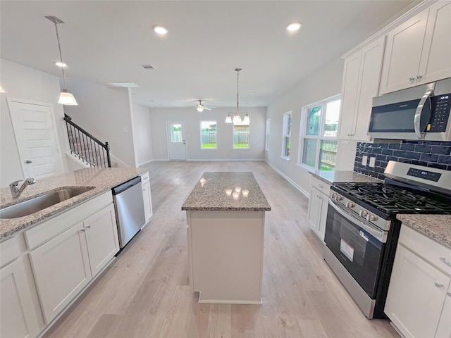 32402 Fly Fish Way, Fulshear, TX 77441 - kitchen featuring stainless steel appliances, light wood-type flooring, a center island, tasteful backsplash, and ceiling fan
