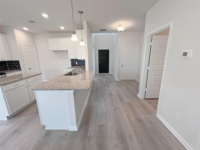 32402 Fly Fish Way, Fulshear, TX 77441 - kitchen featuring decorative backsplash, white cabinets, light wood finished floors, light stone countertops, and recessed lighting