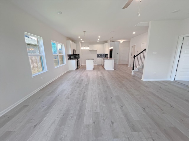 32402 Fly Fish Way, Fulshear, TX 77441 - unfurnished living room featuring stairway, light wood-style floors, recessed lighting, and ceiling fan