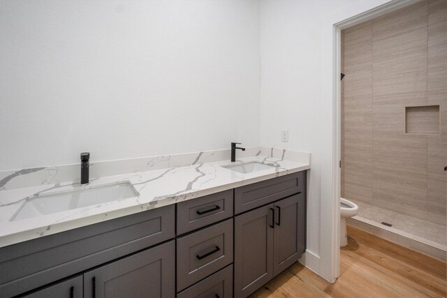 8703 Miller Rd, Magnolia, TX 77354 - bathroom featuring double vanity, wood finished floors, and tiled shower