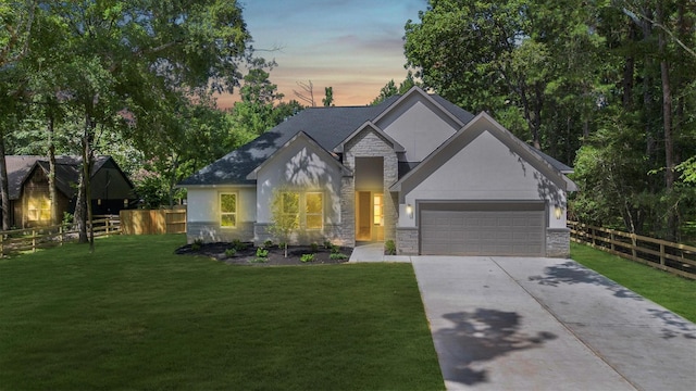 8703 Miller Rd, Magnolia, TX 77354 - view of front of house featuring stone siding, concrete driveway, an attached garage, and stucco siding