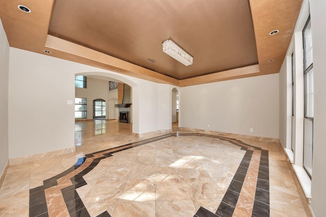 1743 Randons Point Dr, Sugar Land, TX 77478 - unfurnished room with a raised ceiling, inlaid floor details, arched walkways, and recessed lighting