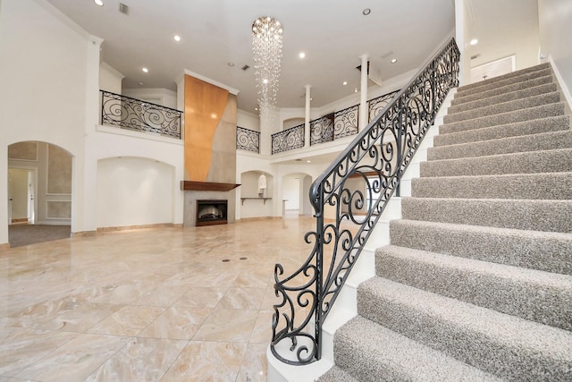 1743 Randons Point Dr, Sugar Land, TX 77478 - stairway featuring arched walkways, a high ceiling, a fireplace, marble tiled floors, and recessed lighting