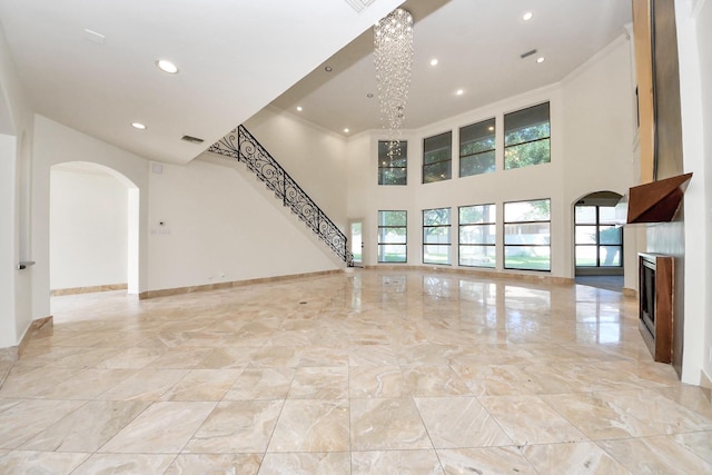 1743 Randons Point Dr, Sugar Land, TX 77478 - unfurnished living room featuring arched walkways, recessed lighting, light marble finish flooring, a fireplace, and a towering ceiling