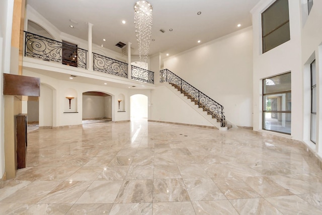 1743 Randons Point Dr, Sugar Land, TX 77478 - unfurnished living room featuring a high ceiling, marble tiled flooring, arched walkways, stairs, and recessed lighting