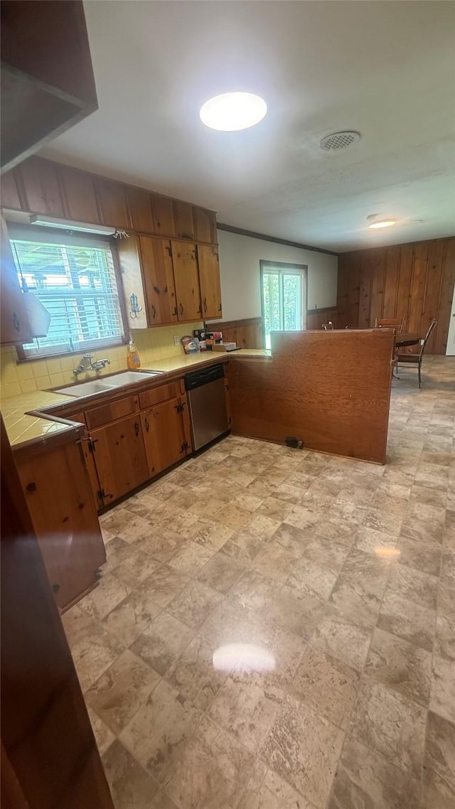 5580 Hooks Ave, Beaumont, TX 77706 - kitchen with dishwasher, wood walls, tile countertops, brown cabinets, and a wainscoted wall