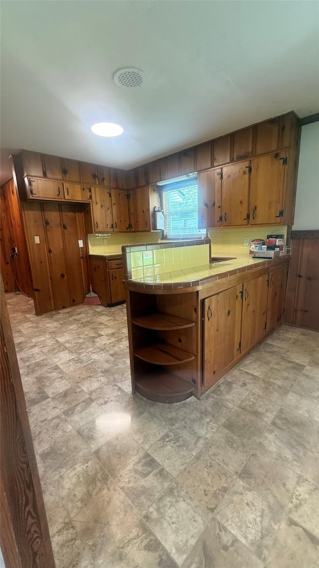 5580 Hooks Ave, Beaumont, TX 77706 - kitchen featuring tile counters, brown cabinetry, and open shelves