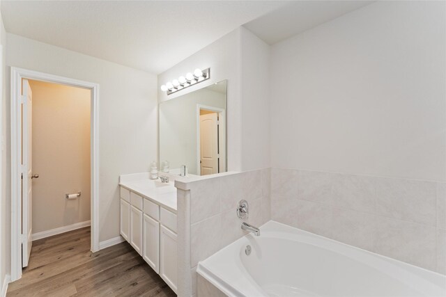 22006 Great Royal Ln, Houston, TX 77073 - bathroom featuring a garden tub, vanity, and wood finished floors