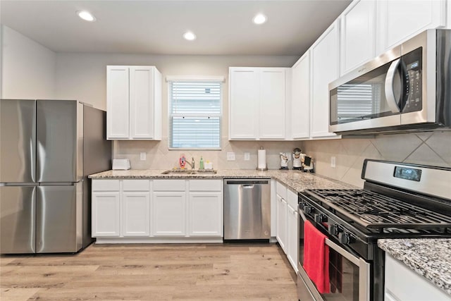 22006 Great Royal Ln, Houston, TX 77073 - kitchen featuring stainless steel appliances, white cabinetry, backsplash, and recessed lighting