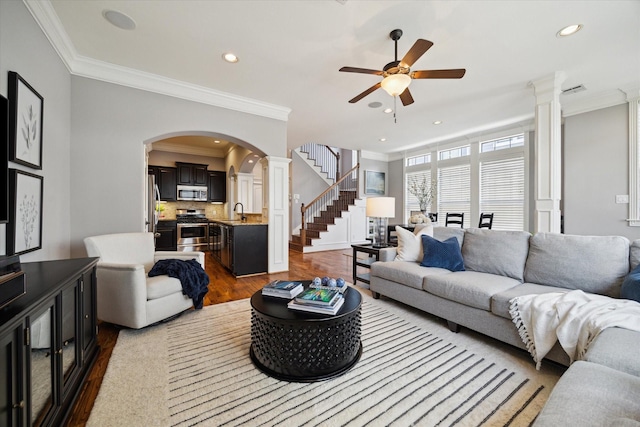 920 Lawrence St Unit D, Houston, TX 77008 - living room featuring dark wood-style floors, arched walkways, ceiling fan, ornamental molding, and stairway
