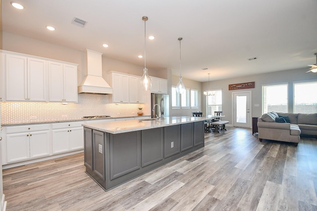 13910 Paseo De La Paz Pl, Cypress, TX 77433 - kitchen with custom exhaust hood, white cabinets, appliances with stainless steel finishes, light wood-style flooring, and recessed lighting